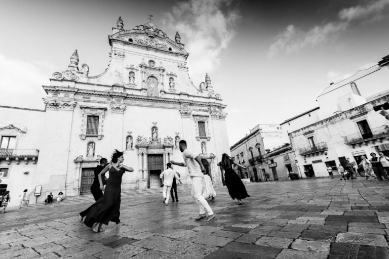 Fotografia in bianco e nero tra persone in movimento e chiesa barocca – Daniele Mercadante