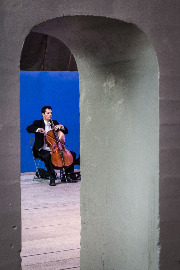 Intimità architettonica: il cello tra muro grigio e blu celeste