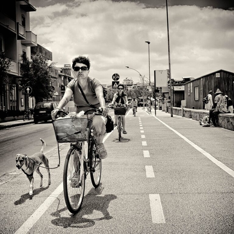 Biker in primo piano: complicità tra persona, cane e dinamica urbana in B/N