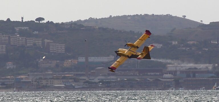Canadair giallo in diagonale: tensione tra velocità, dettaglio e sfondo urbano