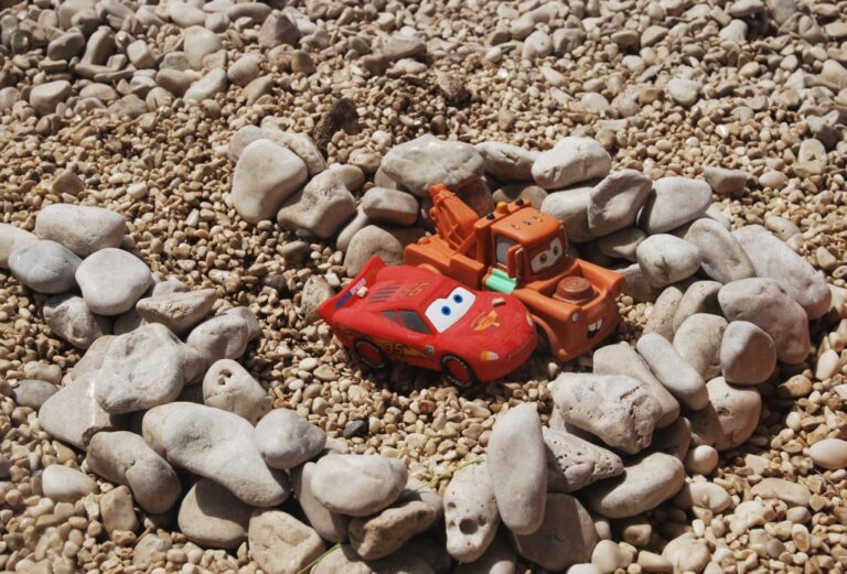 Giochi di colore: due auto giocattolo tra ciottoli, luce di mezzogiorno