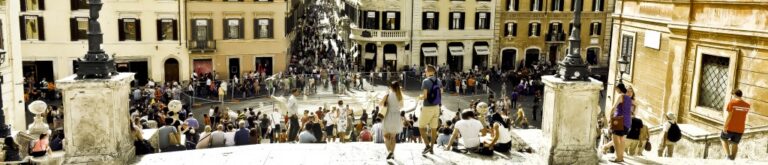 Estate romana: dialogo tra persone e facciate in una luce estiva equilibrata