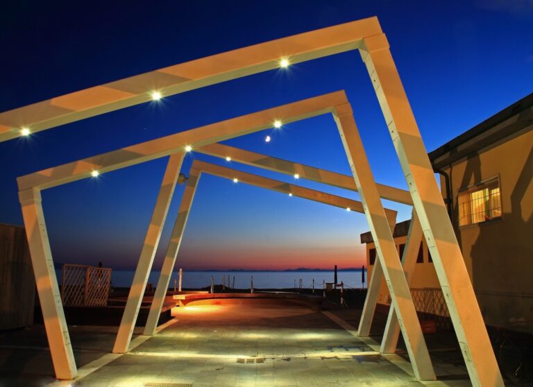 Lungomare in crepuscolo: architettura di archi e luci guide verso l’orizzonte