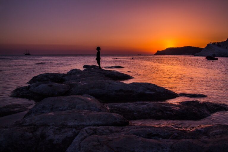 Attesa dolce: luce di tramonto, silhouette sul promontorio e profondità della scena