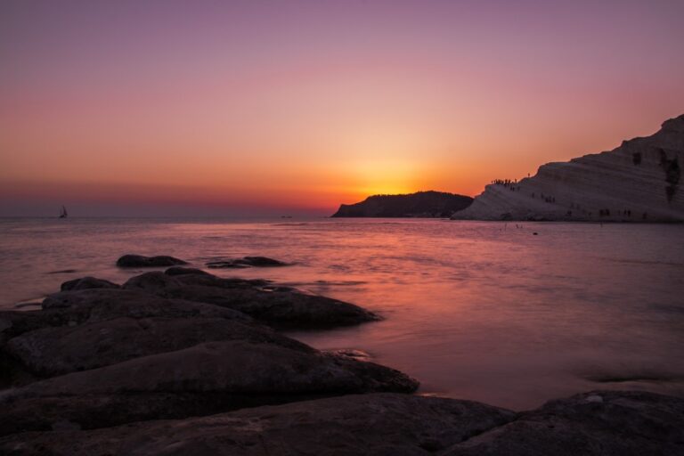 Tramonto su scogliera e costa: quiete, luce e morbidezza dell’acqua antica
