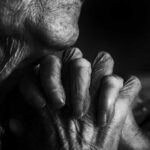 Credere: intimità tattile tra mani, luce morbida e bianco e nero scultoreo