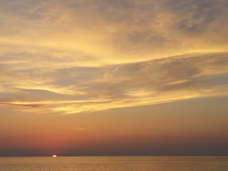 Tramonto sereno: equilibrio di luce, mare e orizzonte dorato nel silenzio