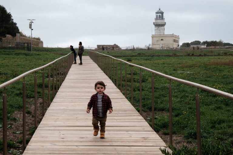 Linea diagonale di legno e faro sull’orizzonte: una scena quotidiana serena