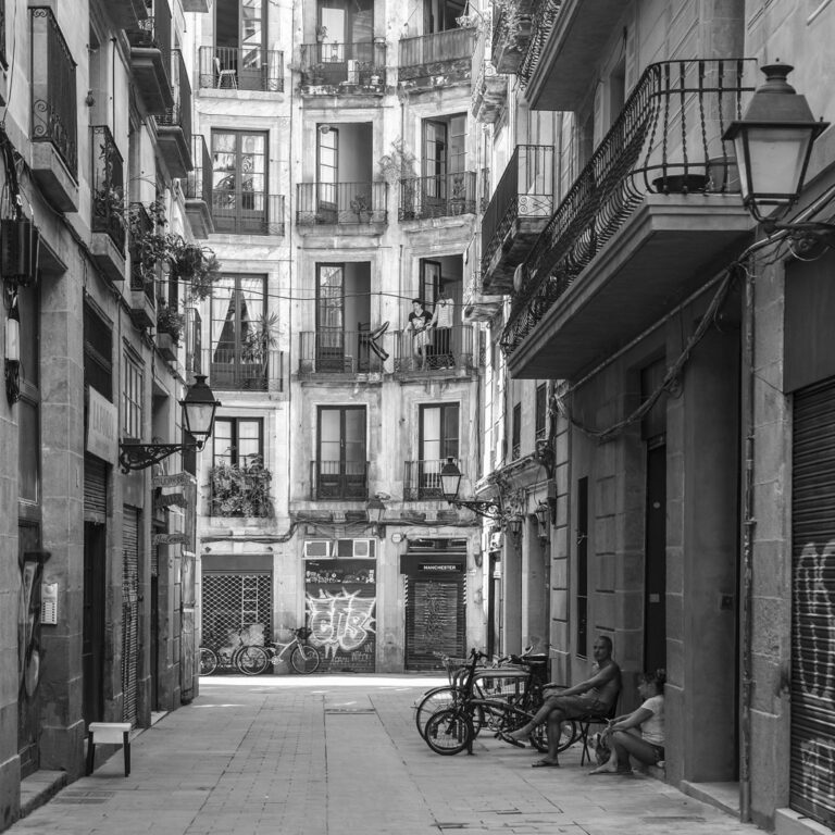 Pausa pomeridiana: quiete urbana tra facciate, ombre e due figure