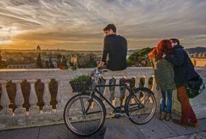 Roma al crepuscolo: una bicicletta, una cornice di pietra e una storia silenziosa della coppia in primo piano