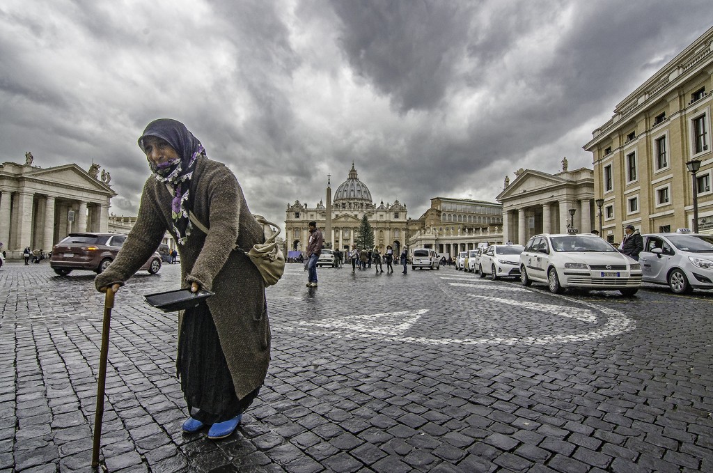 Solitudine urbana: una signora tra pioggia, pietra e movimento in bianco e nero