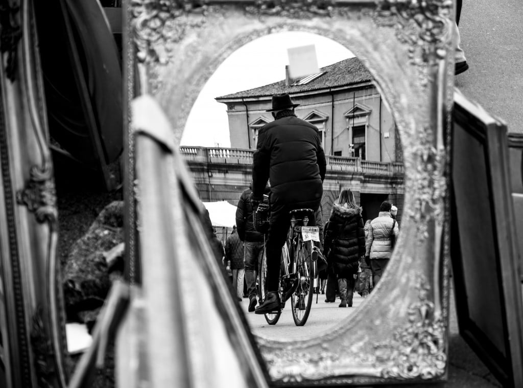 Cornice riflettente e corsa in bianco e nero: tensione tra centro e strada